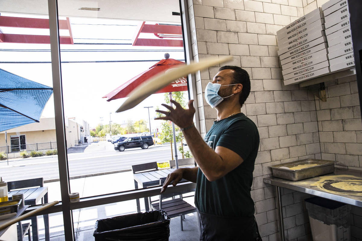 Mimmo Ferraro, owner and chef at Pizza Forte, right, prepares a pizza in the University Gateway ...