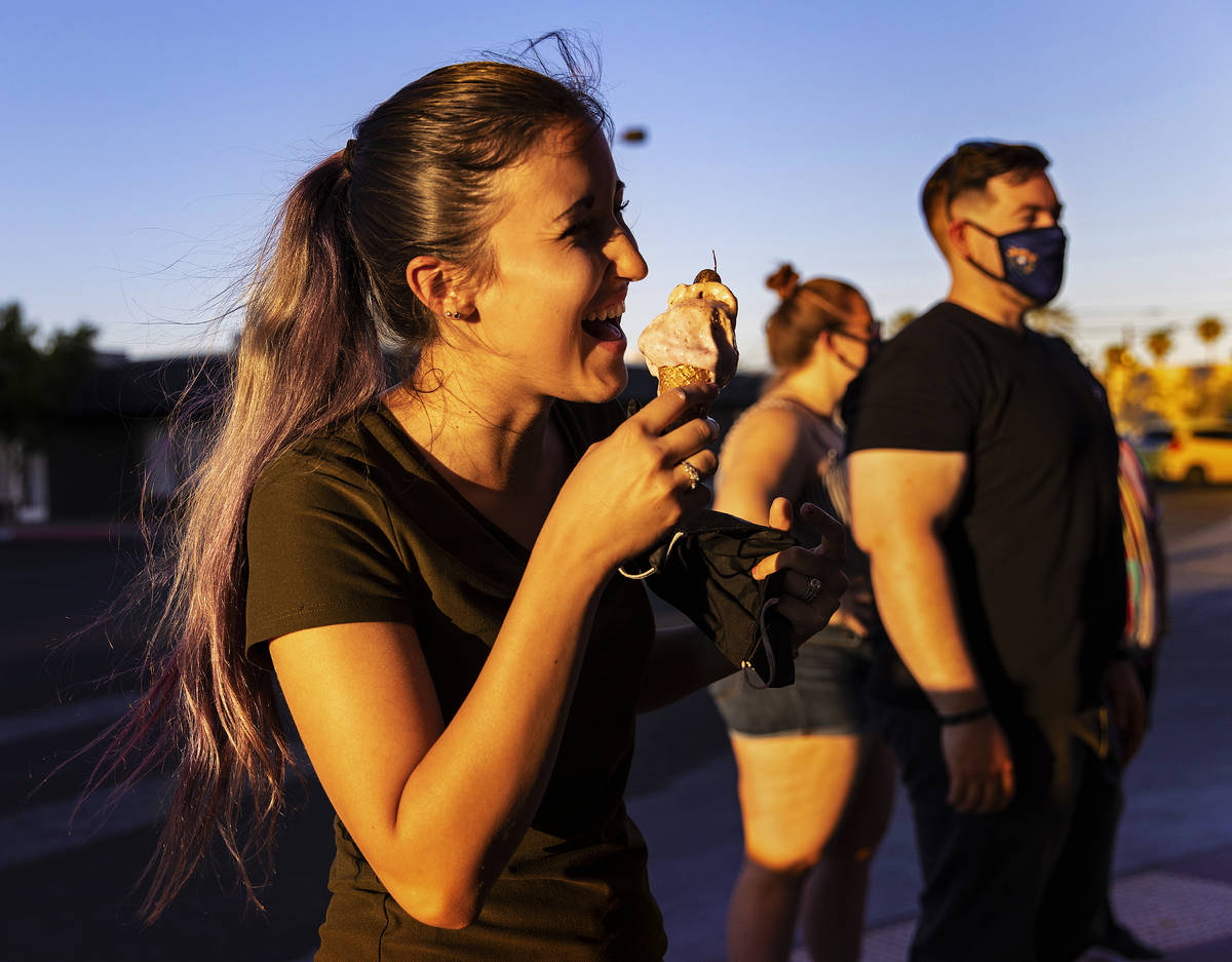 Danielle Jeyes, left, enjoys an ice cream cone called "Birthday Sex" at Paradise City Creamery ...