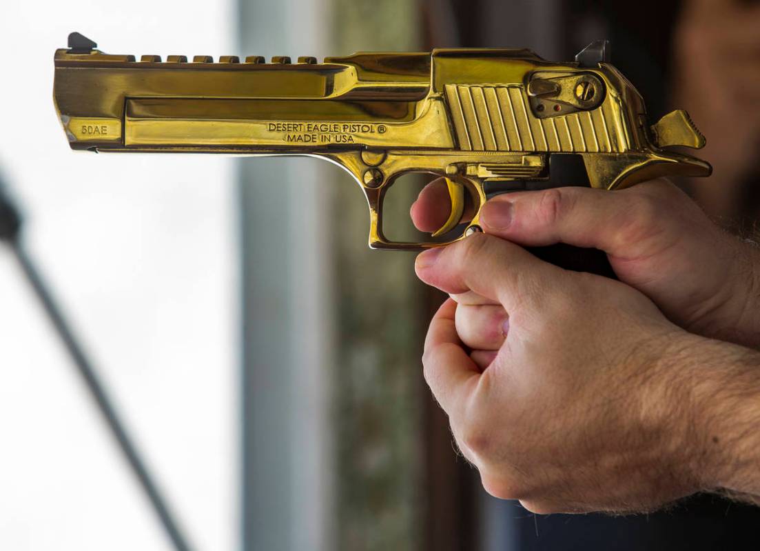 Adrenaline Mountain owner and CEO Eric Brashear readies to fire a titanium gold Desert Eagle pi ...
