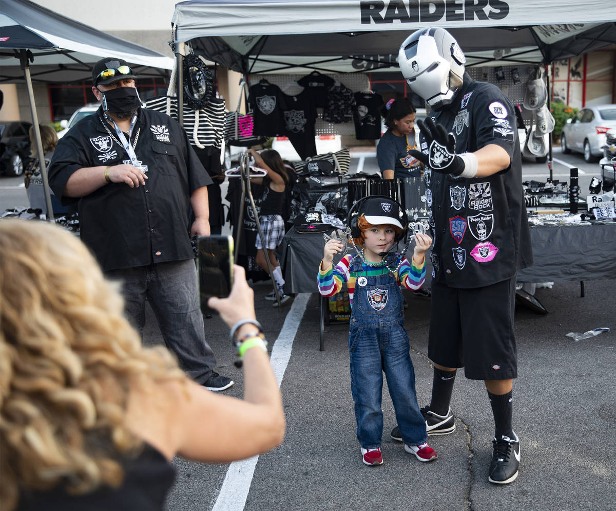 Julian Segura, 5, of Los Angeles, poses with Raider Iron Man, of Arizona, at a Raiders party at ...