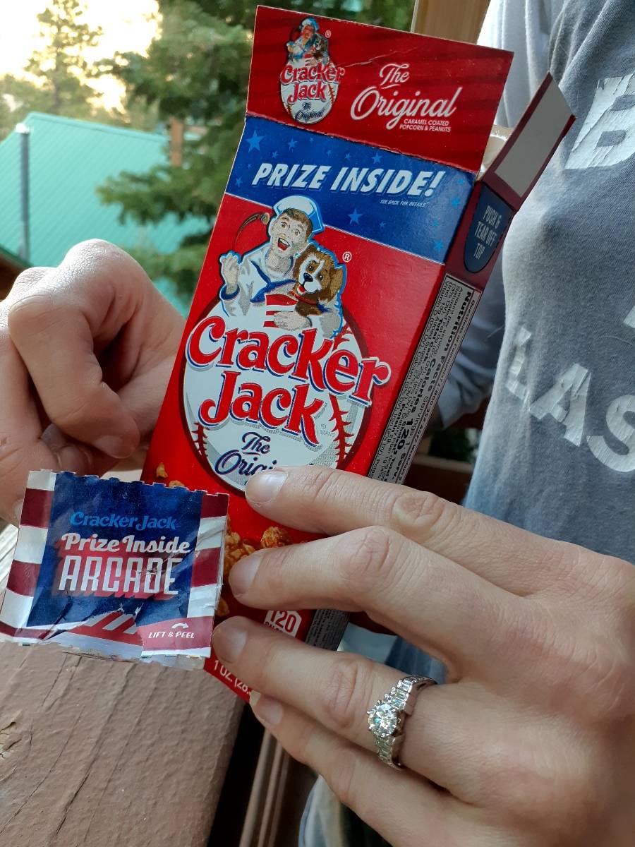 Dani Elizabeth shows off her Cracker Jack box containing her engagement ring from Murray Sawchu ...