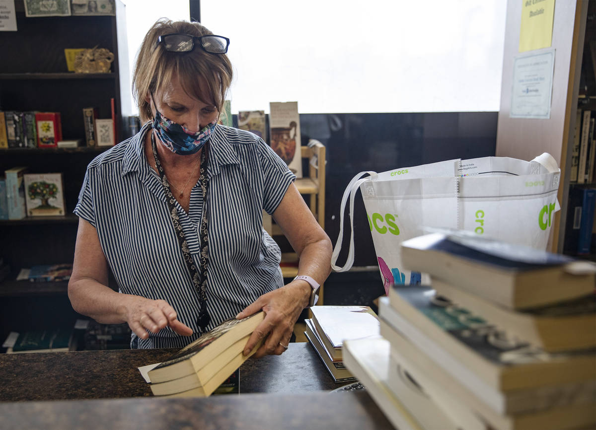Employee Sally Reynolds adds up a customerÕs books at Amber Unicorn Books in Las Vegas, Wednes ...