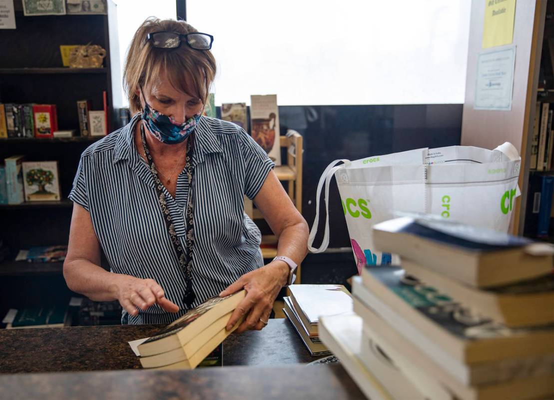 Employee Sally Reynolds adds up a customerÕs books at Amber Unicorn Books in Las Vegas, Wednes ...