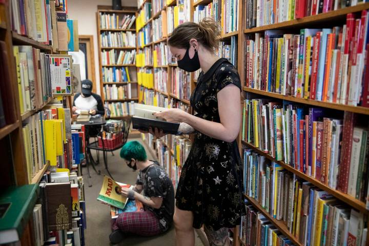 Friends Mercury Taft, left, and Stephanie Lehr, right, shop for books at Amber Unicorn Books in ...