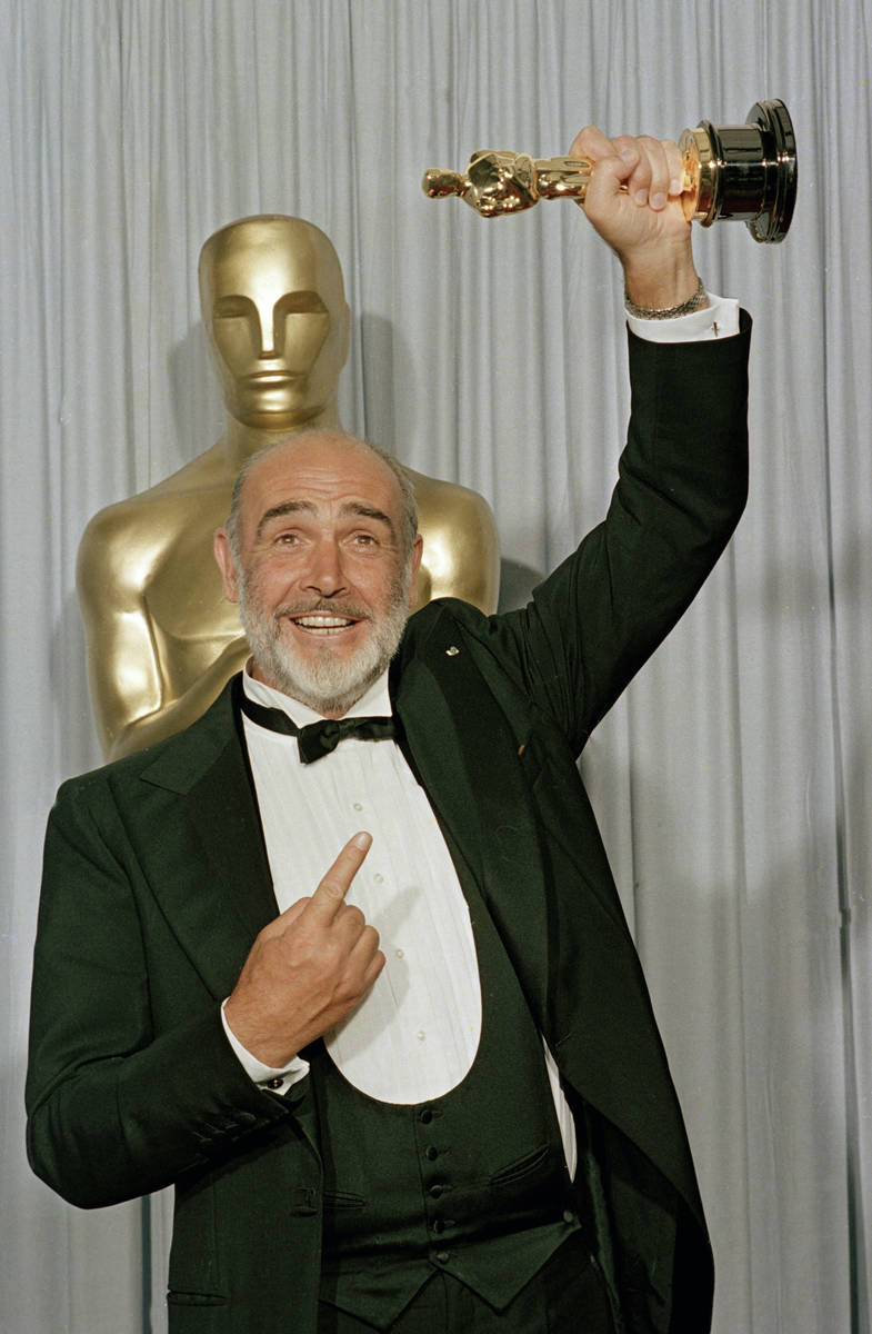 FILE - In this file photo dated April 11, 1988, Sean Connery holds up his best supporting actor ...