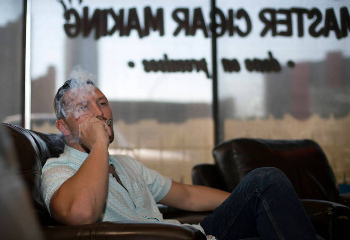 Comedian Rocky Dale Davis smokes a cigar at his regular hangout, En Fuego Cigars & Lounge in La ...