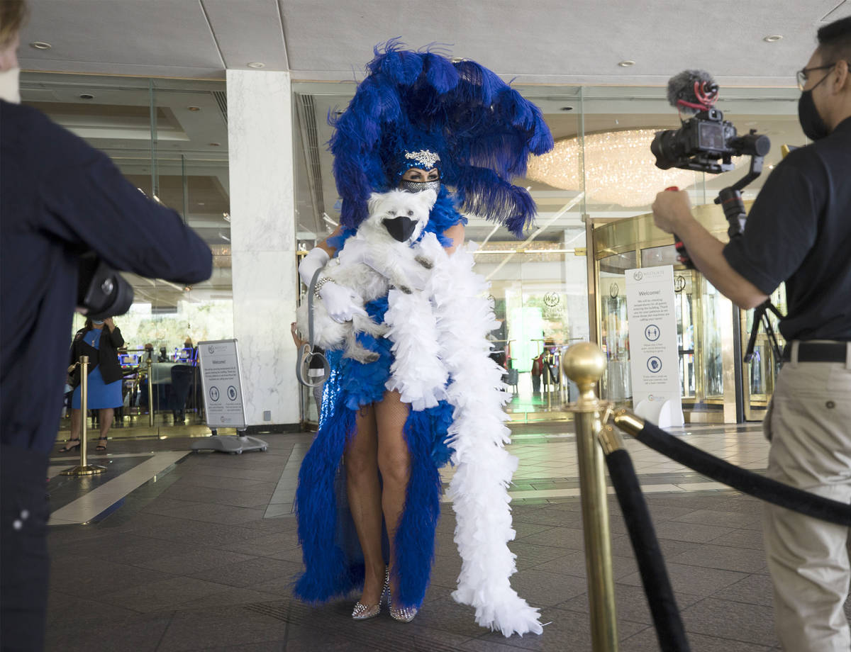 Jennifer Romas, from the Sexxy show, greets guests with the dog Sir Winston of Westgate at the ...