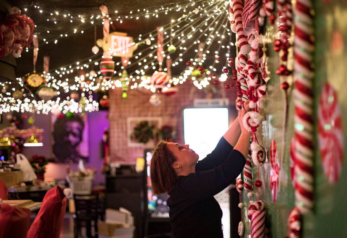 Sara Kiper decorates a wall at the Sand Dollar Lounge in Las Vegas, Monday, Nov. 25, 2019. The ...