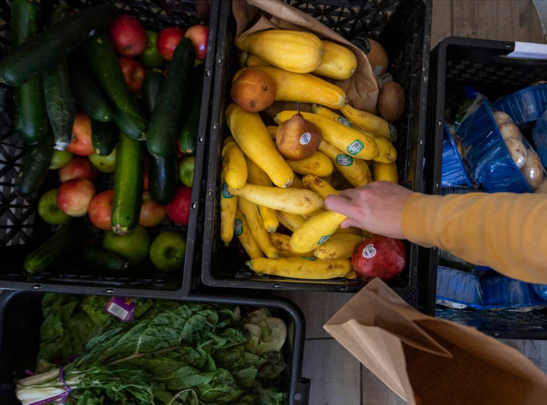 24Meals volunteer Sarah Wittstock, 34, of Las Vegas, packs donated produce to be paired with me ...