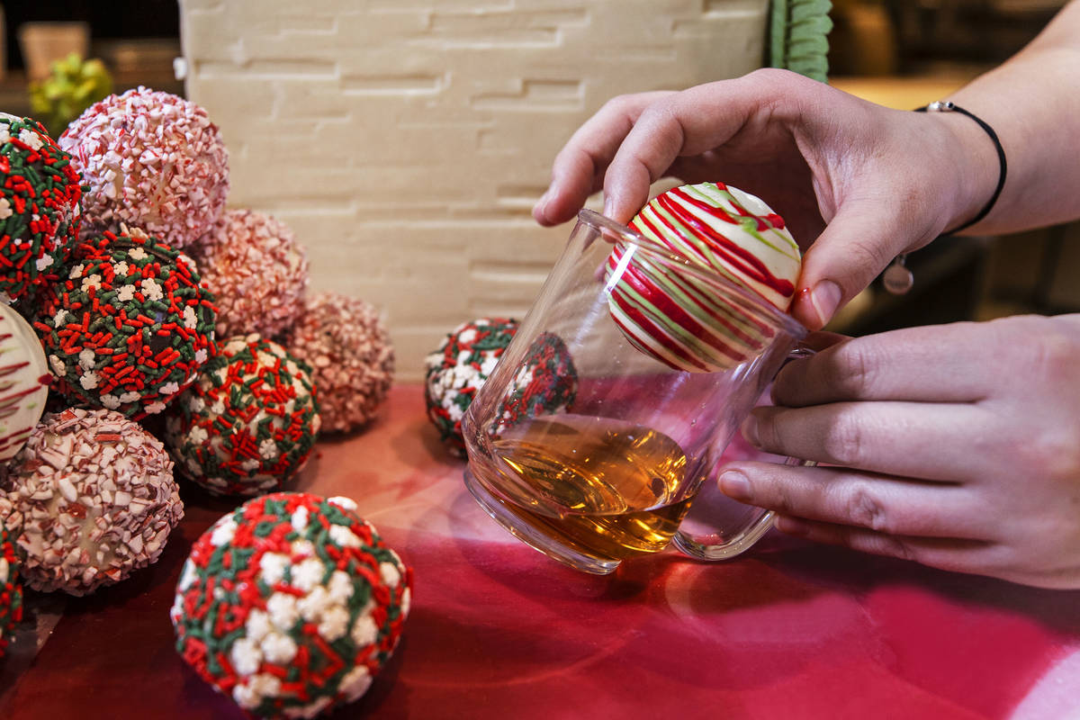 Pastry chef Brittany Simmons places a cocoa bomb into a coffee mug in preparation to make a hot ...