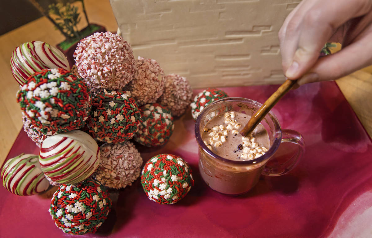Pastry chef Brittany Simmons stirs 8 oz. of boiling milk in a coffee glass containing a cocoa b ...