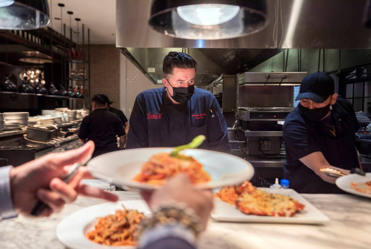 Executive sous chef Christian Gonzalez, center, oversees dishes going out to be served at Buddy ...