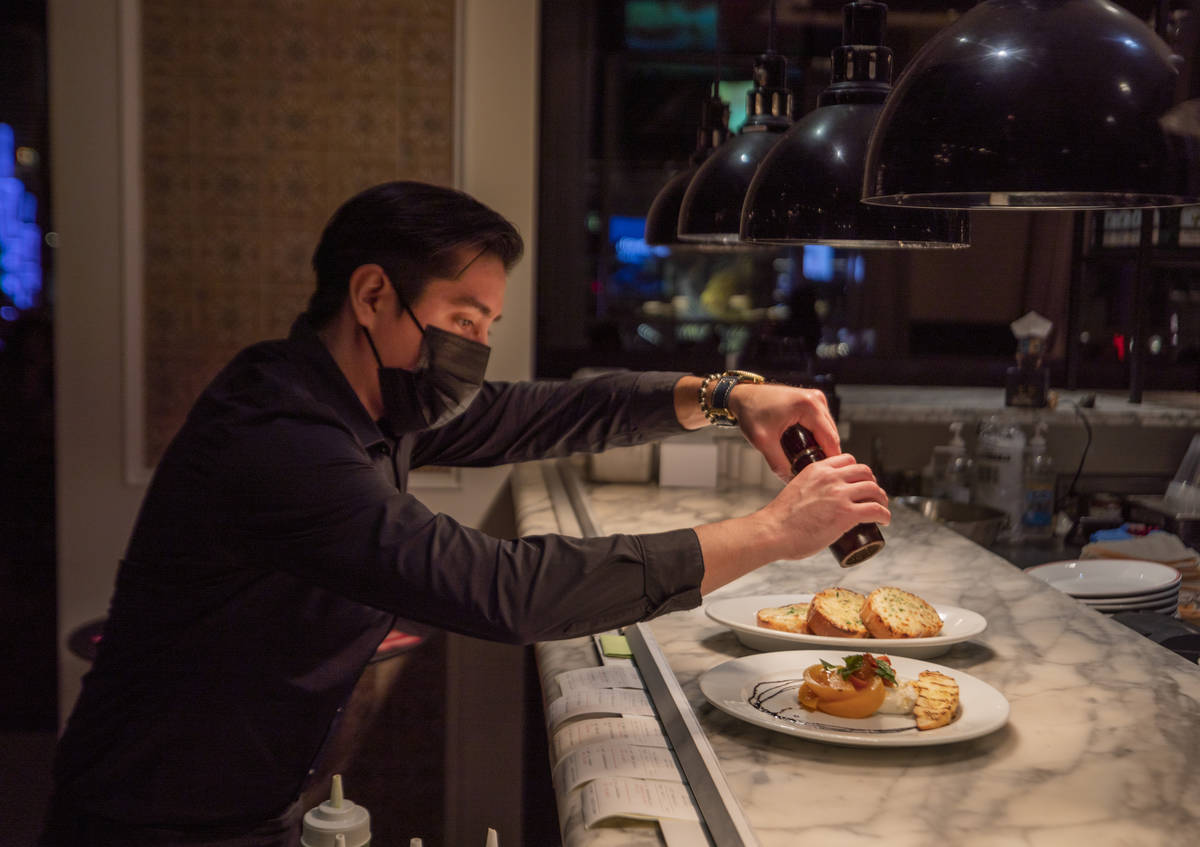 Server Alex Romero puts the final touches on dishes at Buddy V's Ristorante at The Venetian the ...
