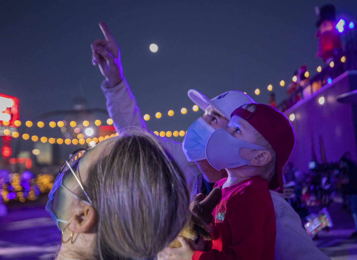 Lina Zuleta, 38, left, Mark White, 56, center, and Logan White, 2, of Henderson, watch the ligh ...