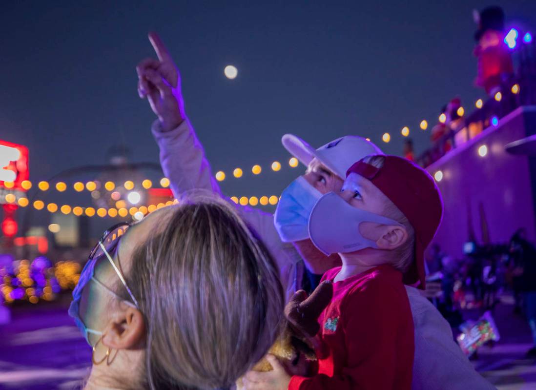 Lina Zuleta, 38, left, Mark White, 56, center, and Logan White, 2, of Henderson, watch the ligh ...