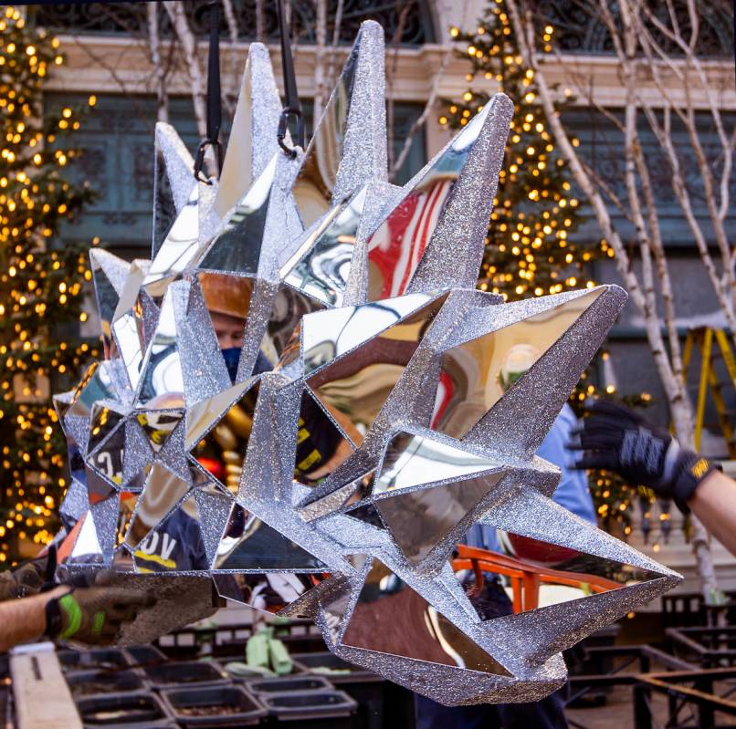 A crew member is reflected in a large crystal piece being erected about the new winter display ...