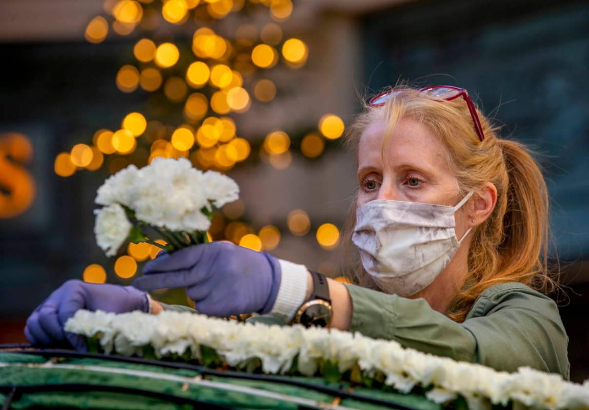 Artist Susie Fernandez adds carnations to the body of a Coca-Cola polar bear about the new wint ...