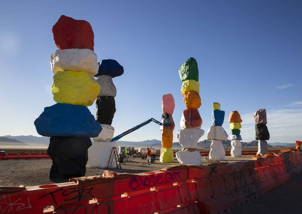 Workers from Vergith Contracting Co. begin prepping the Seven Magic Mountains totems for painti ...