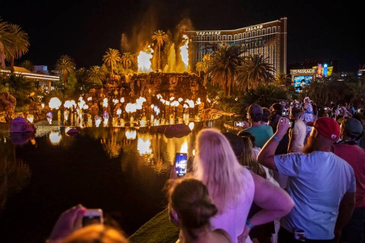 People on the Strip watch the first volcano show since the reopening of the The Mirage earlier ...