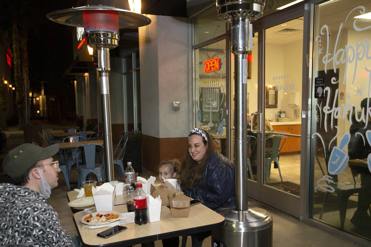 Avi Weiss, left, Sara Weiss, 4, and Julie Weiss, of New York, dine outdoors at Kosher Chinglish ...