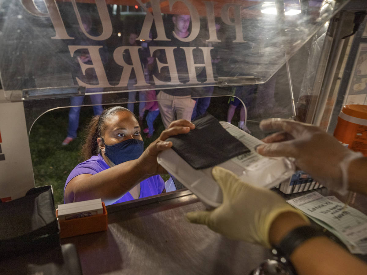 Owner Jinelle Batista picks up a customer order from YourPanadas empanada truck, at Aviata Apa ...