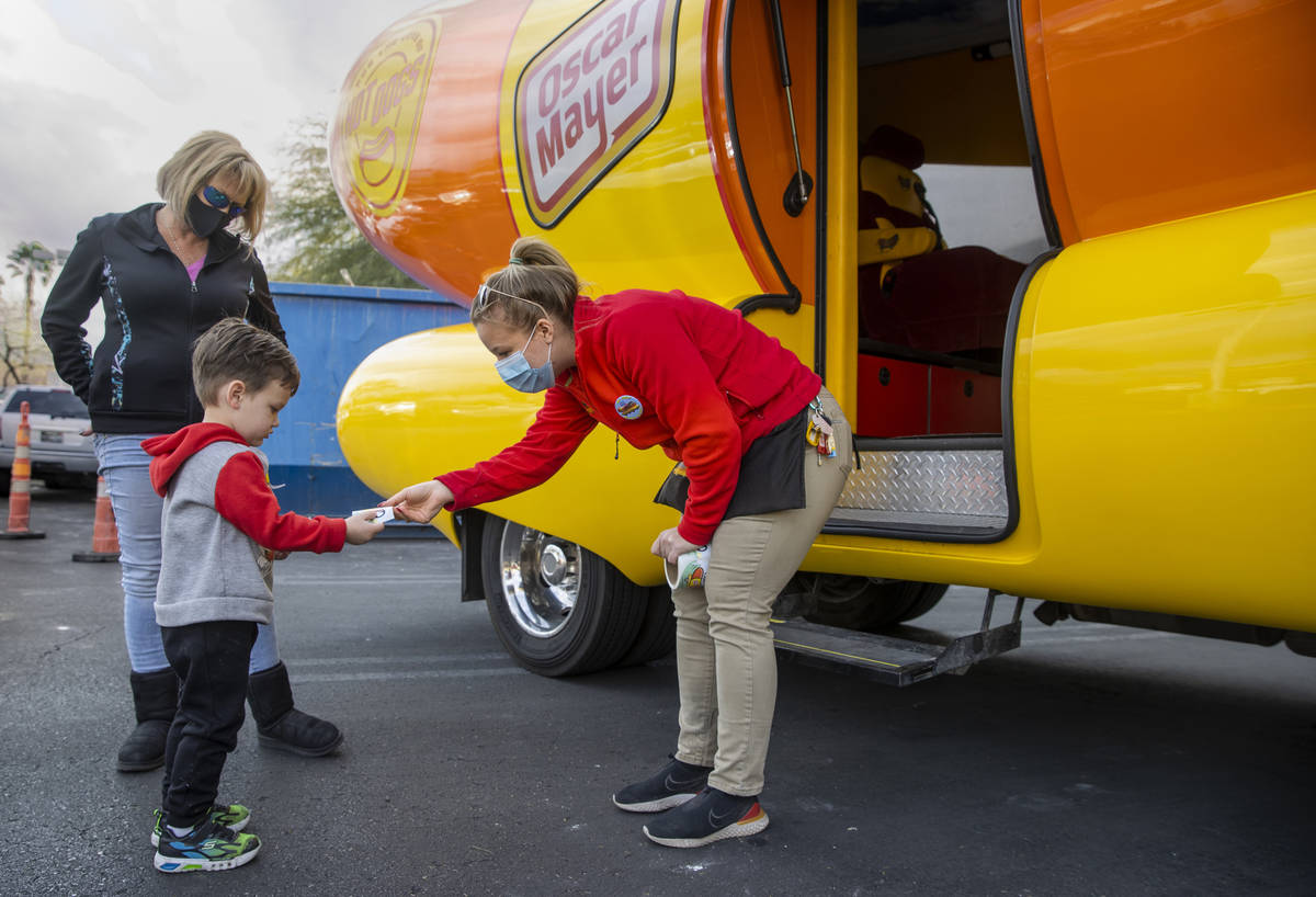 Niener Wiener, right, hands Brenden McCormack, 3, a sticker as he and aunt Corinne Weidman visi ...