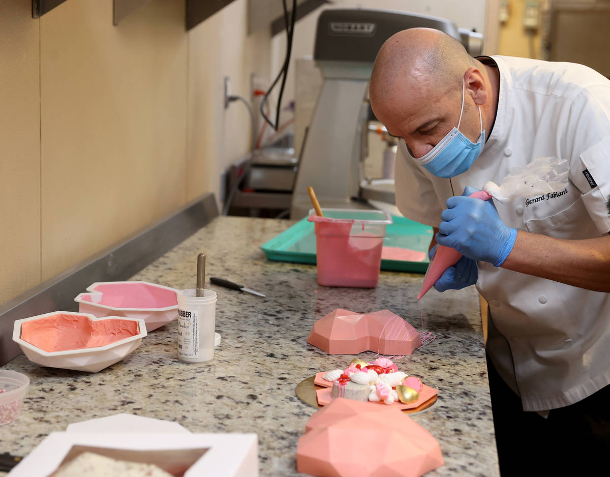 Red Rock Resort executive pastry chef Gerard Fabiani puts the finishing touches on the exterior ...