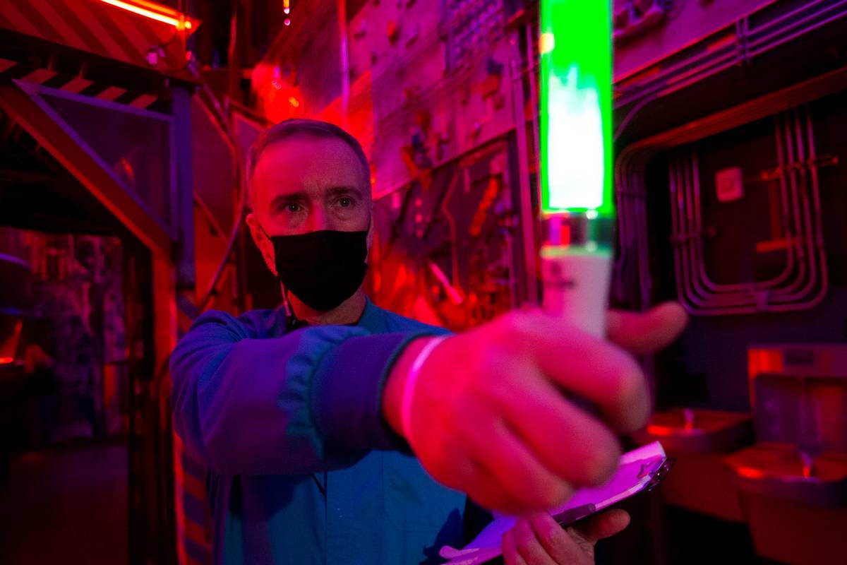Jamie Morris, a "DART scientist" in one of the dimensions at the Omega Mart, uses a device to r ...