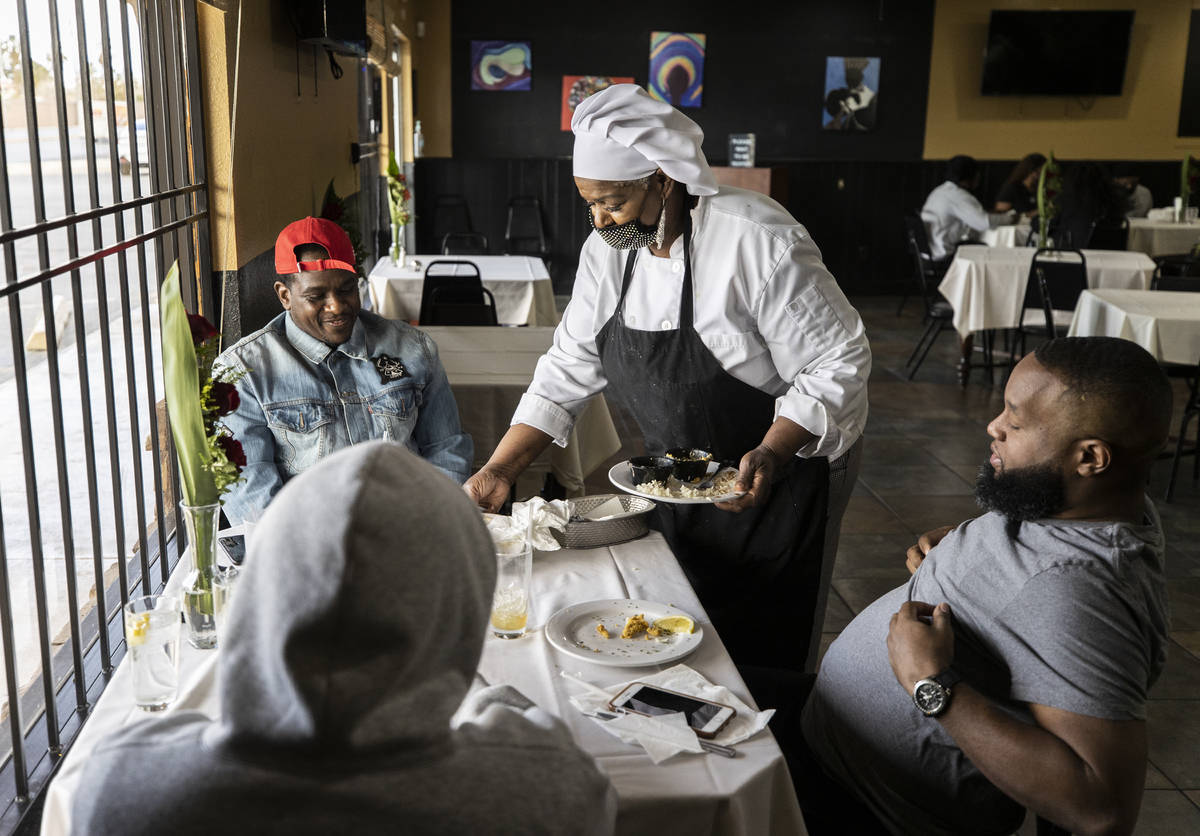 Chef Carol Hampton-Gray clears plates from a table at Chef Carol's Southern Kitchen in the Hist ...