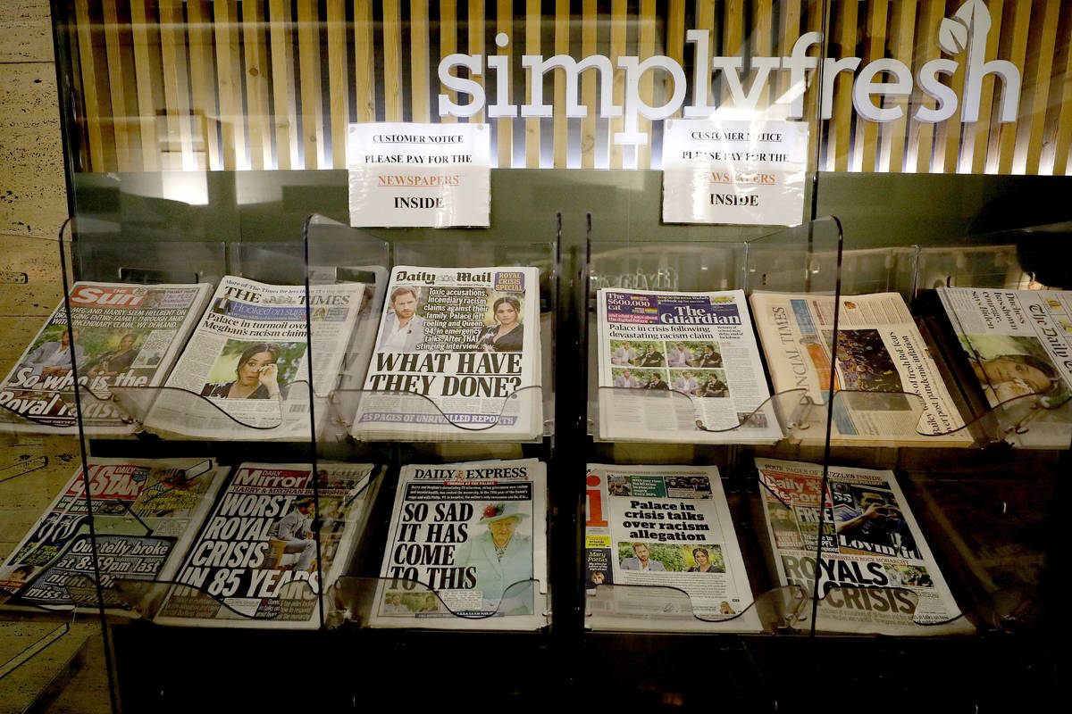 Newspapers headlining Prince Harry and Meghan’s explosive TV interview are displayed for ...