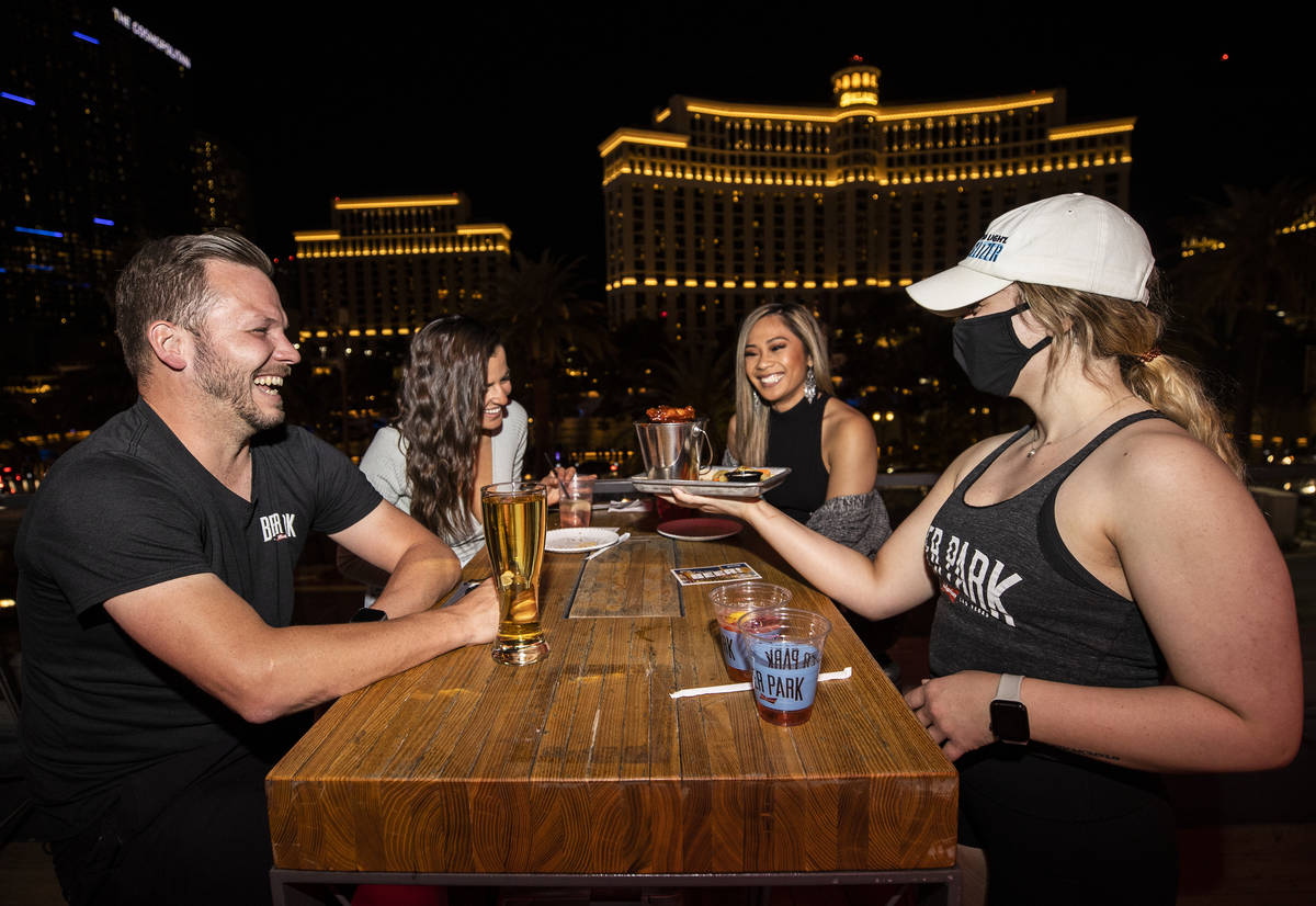 Server Brittany Myers delivers wings to Trevor Bloom, May Mendez and Michelle Janeo at Beer Par ...