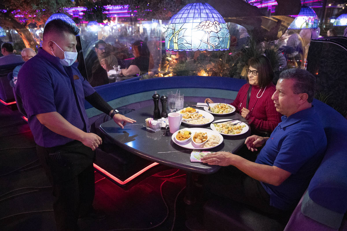 Server Angel Hernandez delivers food to Rosalba Gonzales and her husband Alberto of San Diego, ...