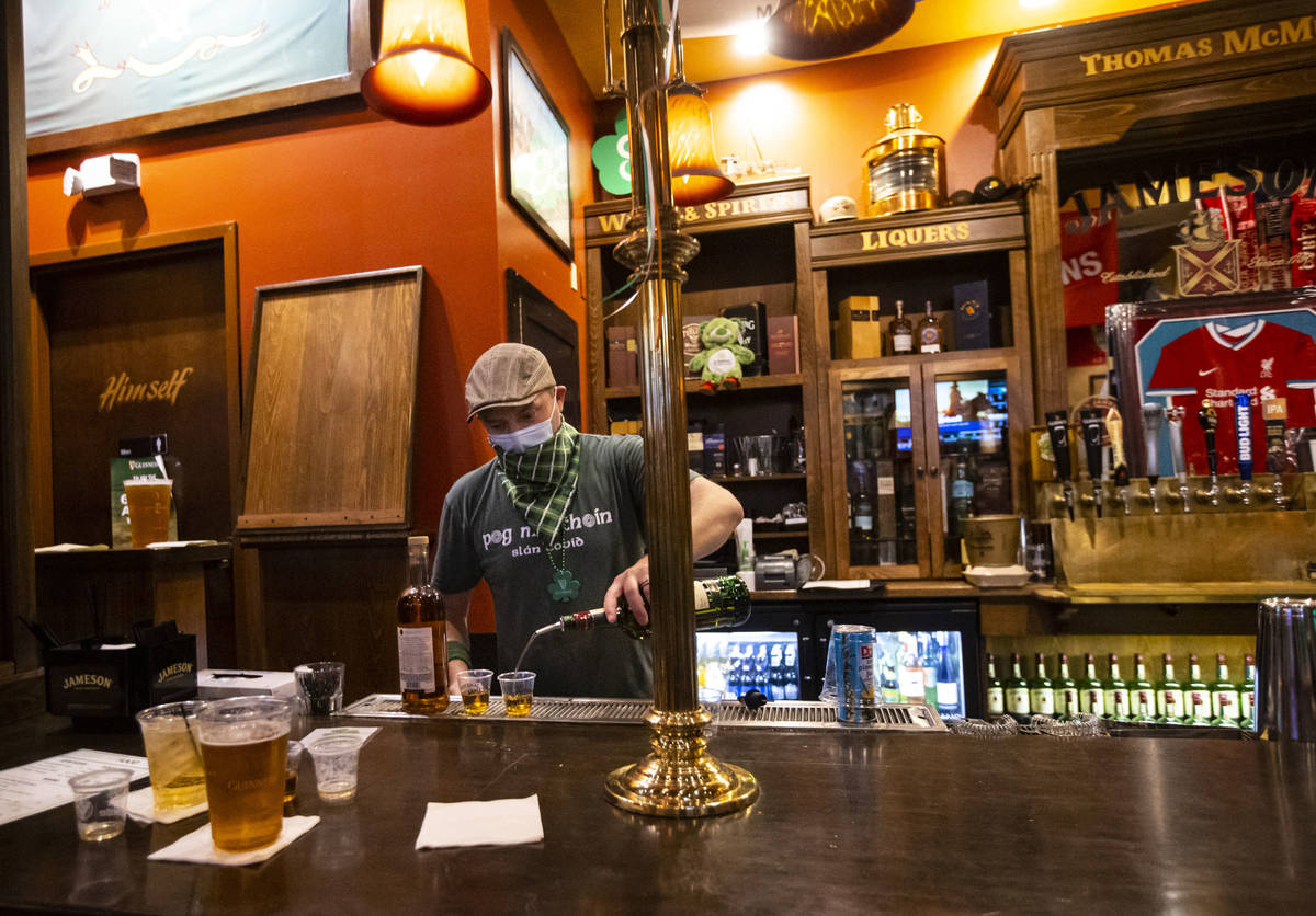 Bartender Paul Walsh Jr. prepares drinks as people gather to celebrate St. Patrick's Day at McM ...