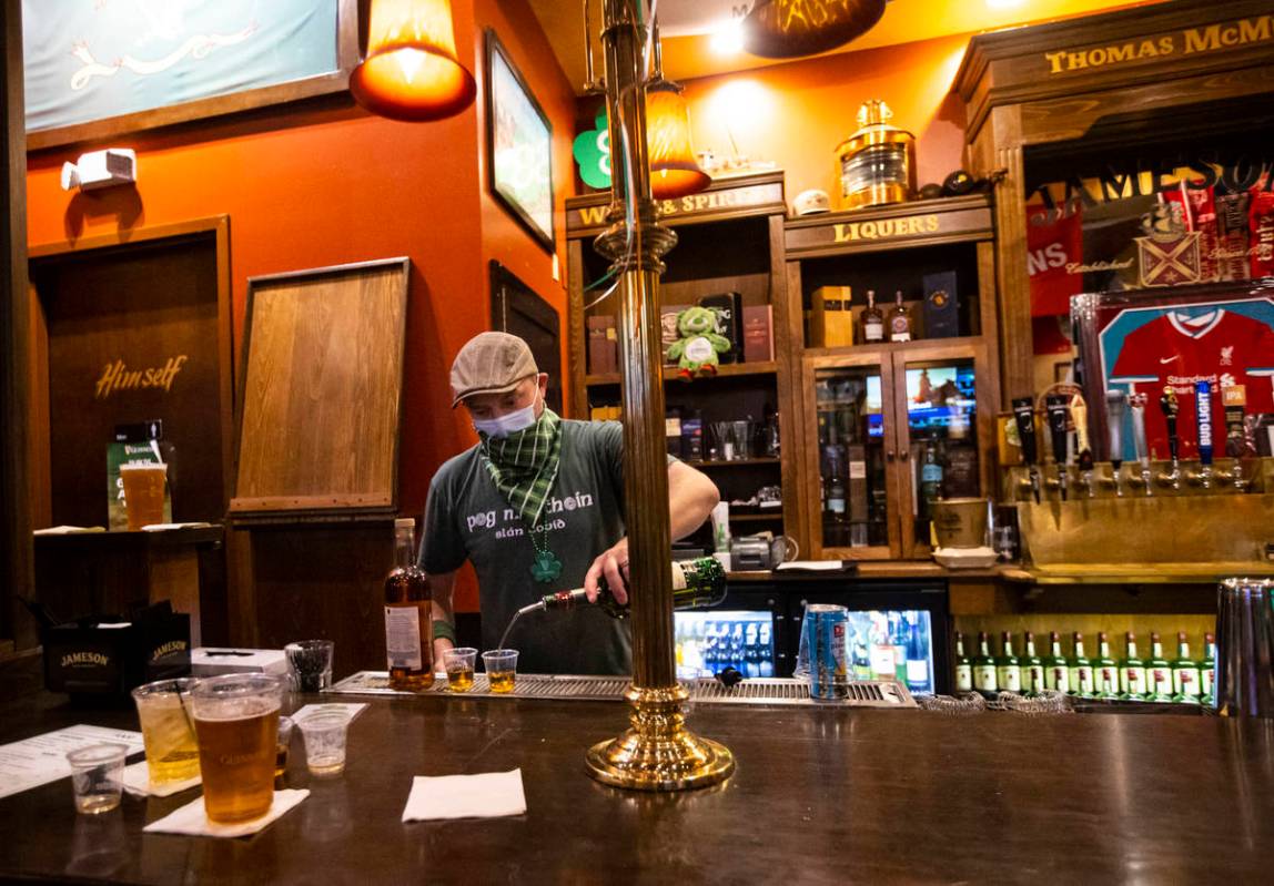 Bartender Paul Walsh Jr. prepares drinks as people gather to celebrate St. Patrick's Day at McM ...