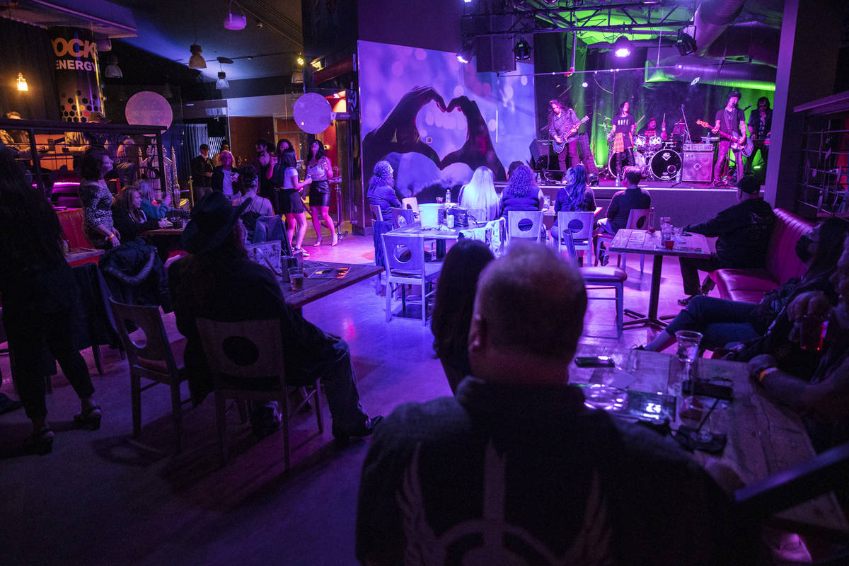 People watch a performance by the Heartbreakers inside of the newly opened Rockstar Bar at the ...