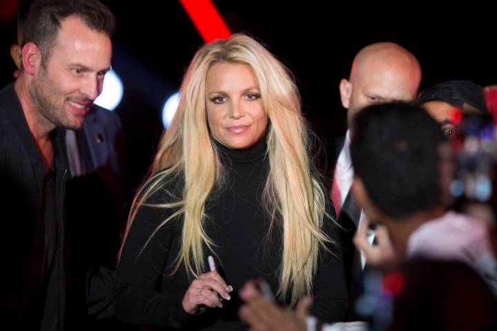 Britney Spears signs an autograph during an event to announce her residency at The Park Theater ...