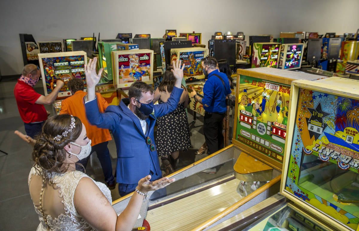 Newlyweds Amber and Brian Dougherty of Phoenix enjoy playing some games along with their weddin ...