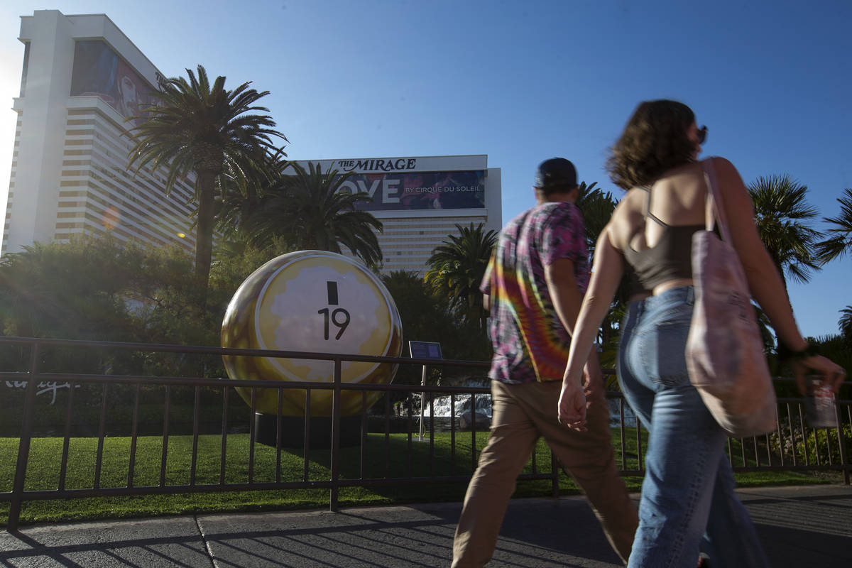 Pedestrians pass a 200-pound bingo ball by artist Jerry Misko, displayed in front of The Mirage ...