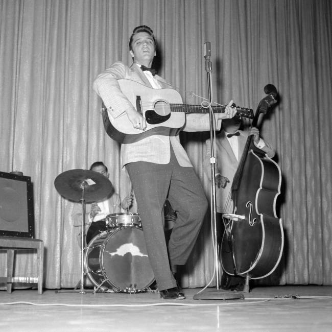 Elvis Presley performs, along with D.J. Fontana on drums and Bill Black on bass, in the New Fro ...
