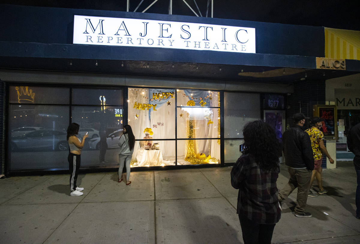 Passersby watch as Heidi Rider performs from the windows of the Majestic Repertory Theatre in t ...