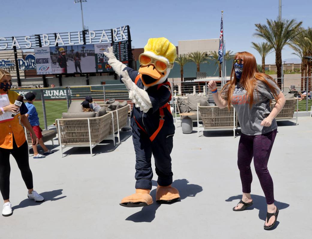 Spruce the mascot greets competes with Teresa Thurtle as they are projected on the big screen a ...