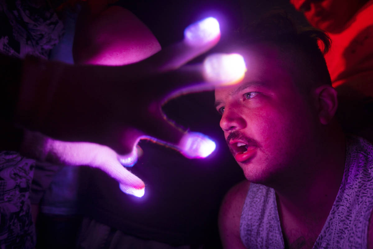 An concert goer enjoys a light show at Insomniac presents Deadmau5 at The Downtown Las Vegas Ev ...