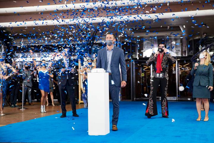 Anthony Carano, president and chief operating officer of Caesars Entertainment, presses a butto ...