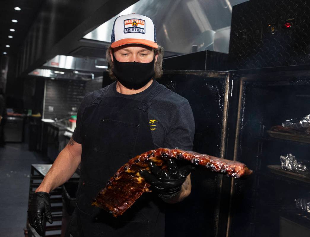 Joe Woodel, BBQ pitmaster, takes a rack of smoked pork ribs out of the smoker at The Beast by T ...
