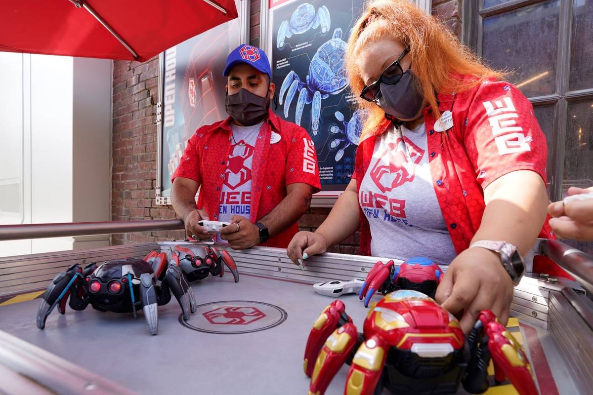 Cast Members Ryan Garcia, left, and Cristal Aros demonstrate Spider-Bots toys at the Avengers C ...