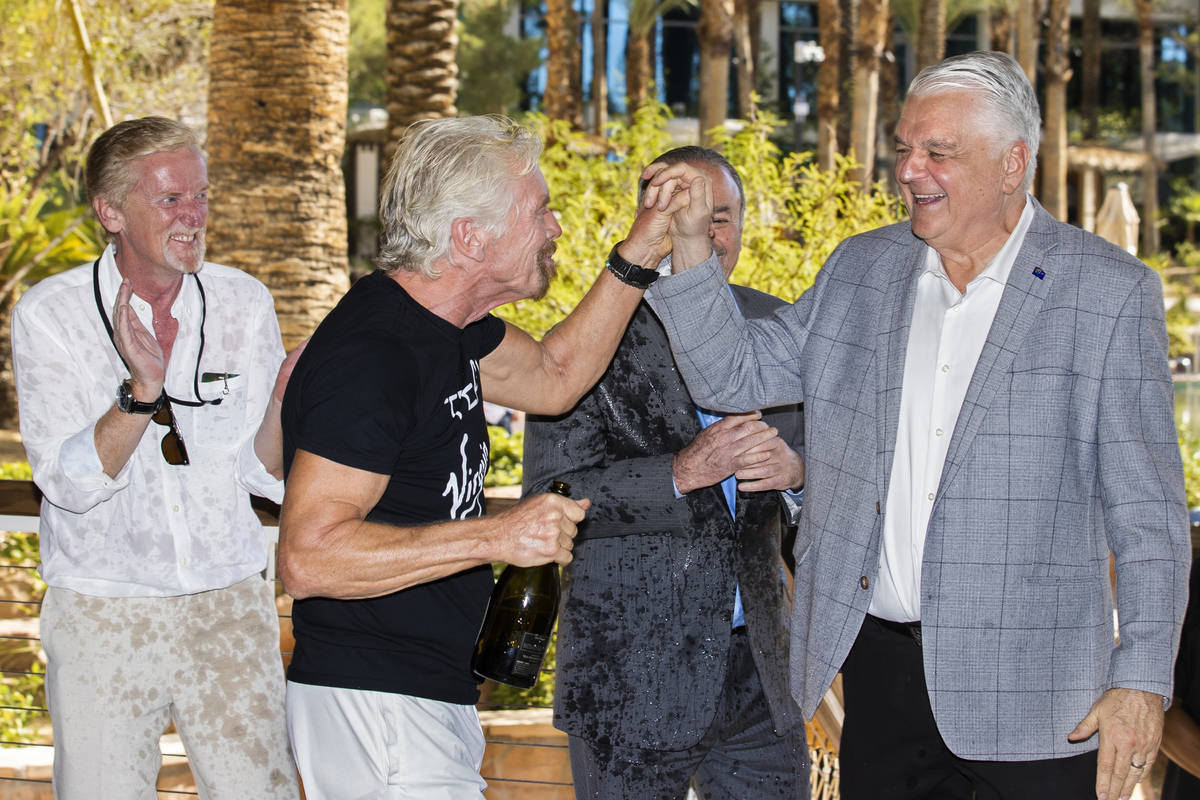 Sir Richard Branson, second from left, founder of Virgin Group, high fives Gov. Steve Sisolak a ...