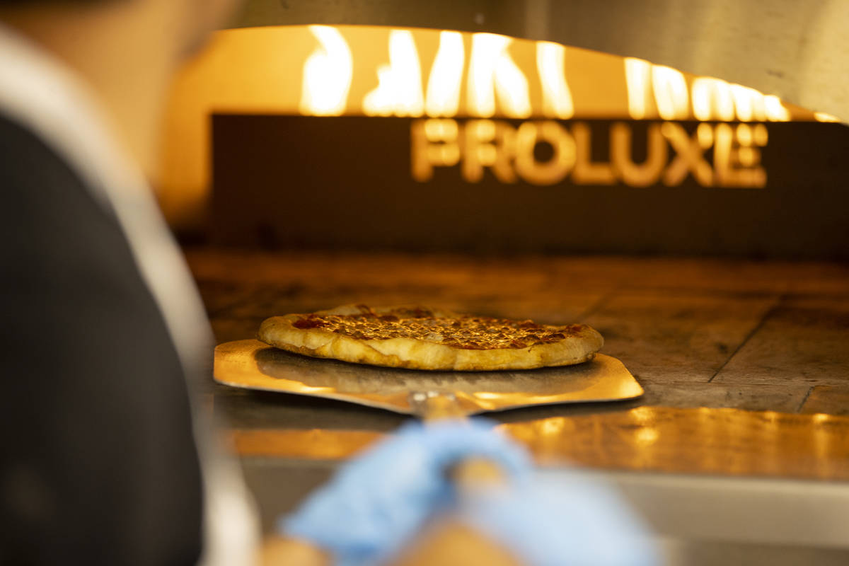 A pizza is taken out of the oven at the Fly Pie drive-thru pizza restaurant at St. Rose and Cor ...