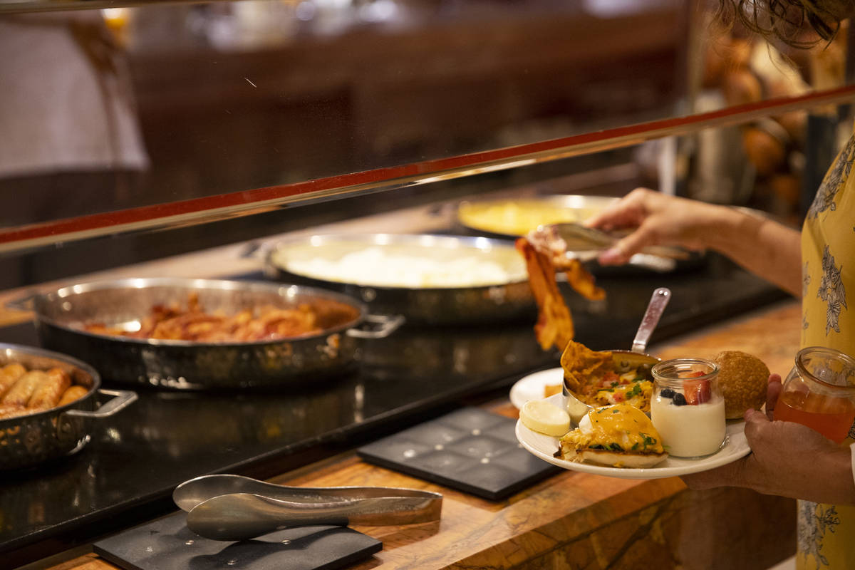A person serves their own food at The Buffet at Wynn Las Vegas, Wednesday, June 30, 2021 in Las ...