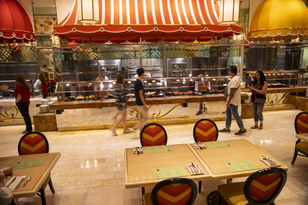 People walk past the food stations at The Buffet at Wynn Las Vegas, Wednesday, June 30, 2021 in ...