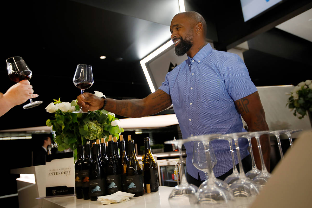 Former NFL football player Charles Woodson talks with a guest when he promotes his "Intercept" ...